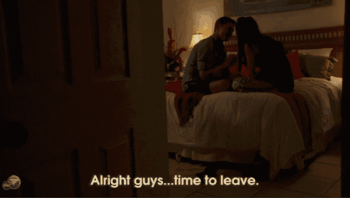 a man and woman kissing on a bed with the words " alright guys time to leave "