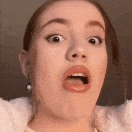 a young woman is making a funny face with her mouth open .