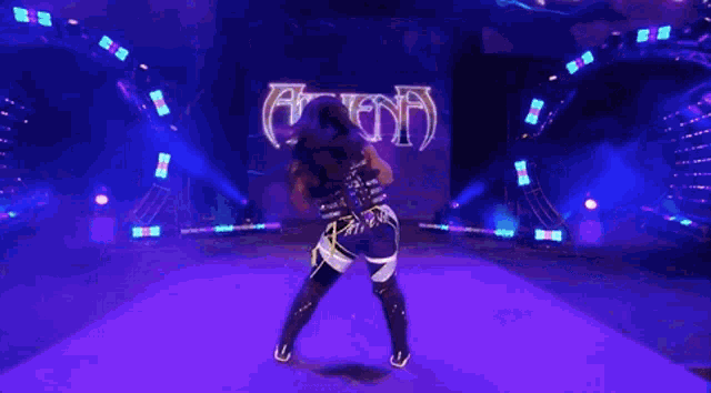 a woman is standing on a stage in front of a large screen .