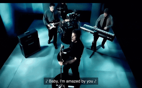 a man playing a guitar in a band with the words baby i 'm amazed by you below him