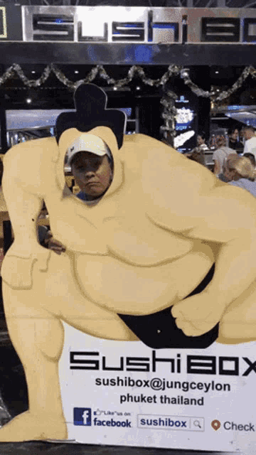 a cardboard cutout of a sumo wrestler poses for a photo