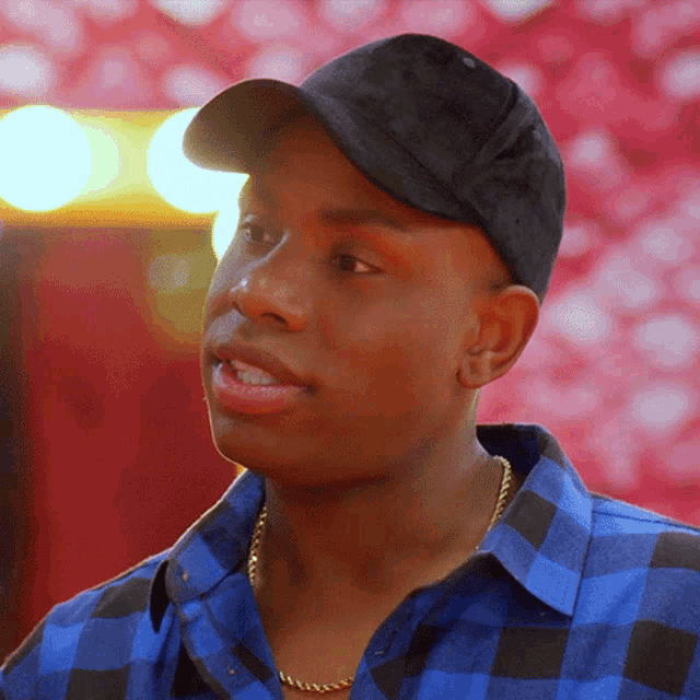 a man wearing a hat and a plaid shirt
