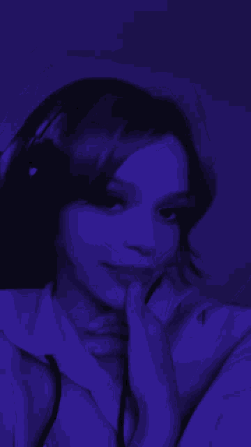 a woman 's face is visible in a purple light