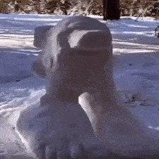 a statue of a bear made out of snow is sitting in the snow