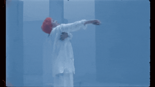 a man in a white suit and red helmet is kneeling down