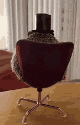 a chair with a top hat on it is sitting on a table