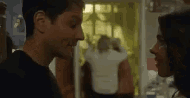 a man and woman are looking at each other in a room .