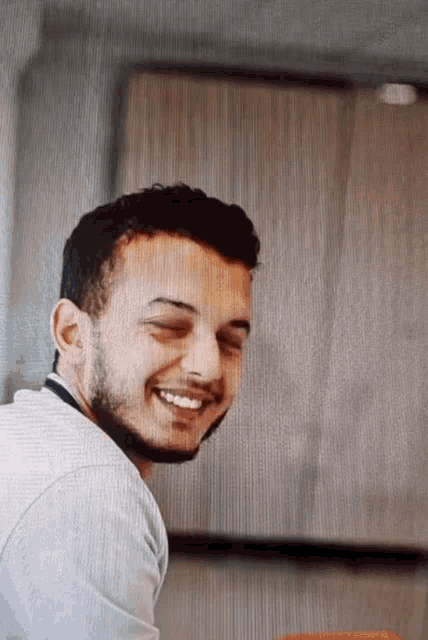 a man with a beard is smiling and looking at the camera