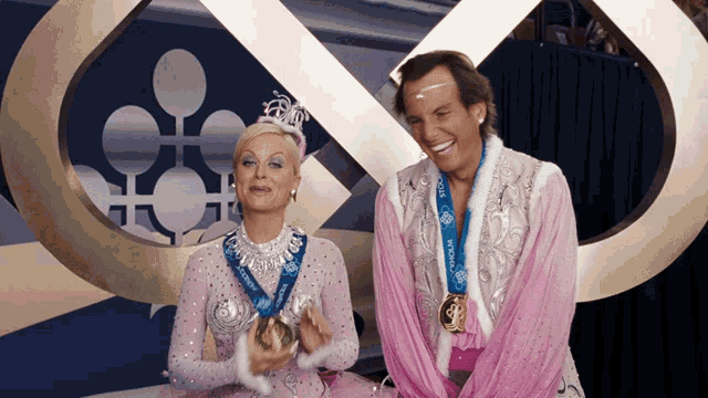 a man and a woman are wearing medals that say ' polar ' on them
