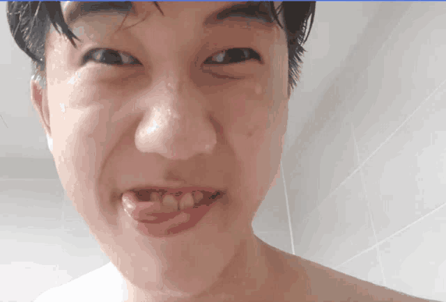 a close up of a man 's face with his tongue hanging out