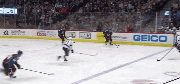 a hockey game is being played in front of a geico advertisement
