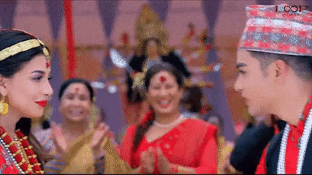 a man and a woman are standing next to each other in front of a crowd .