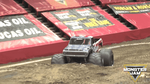 a monster jam truck is driving down a dirt road