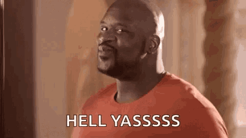 a bald man in a red shirt is making a funny face and saying `` hell yasssss '' .