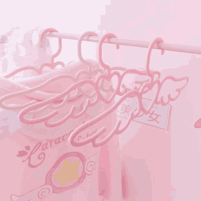 a pink shirt with a star on it is hanging on a rack