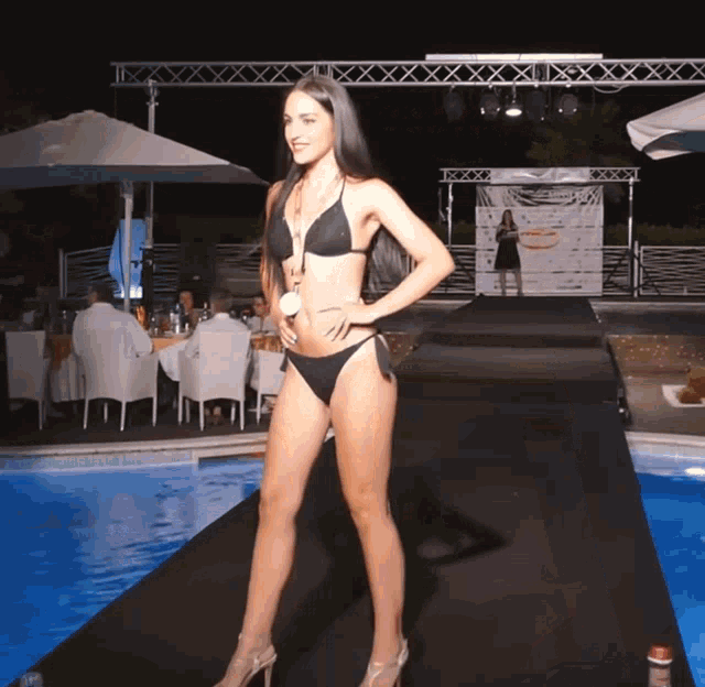 a woman in a bikini walking down a runway