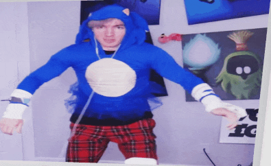 a man dressed as sonic the hedgehog is standing in front of a wall with pictures