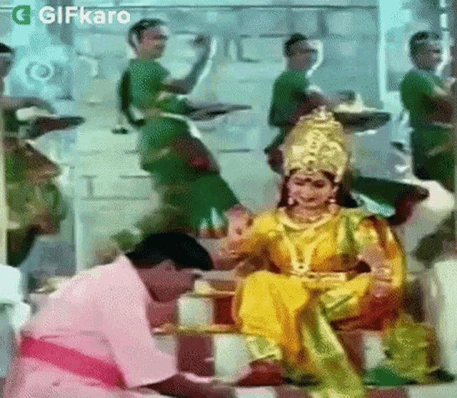 a man is kneeling down in front of a woman in a yellow and green dress .