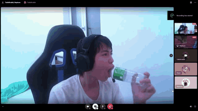 a man is drinking from a plastic bottle in a video conference