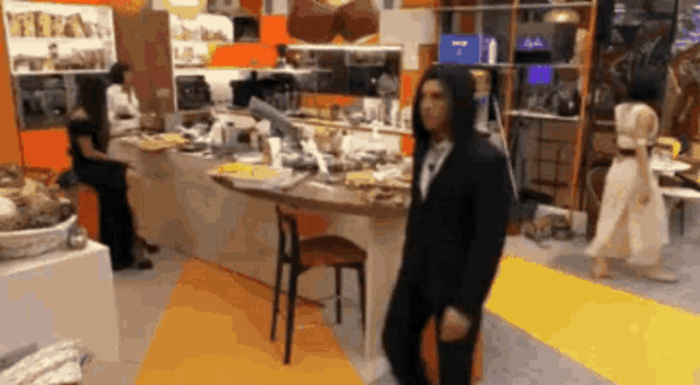 a man in a black suit is dancing in a messy room