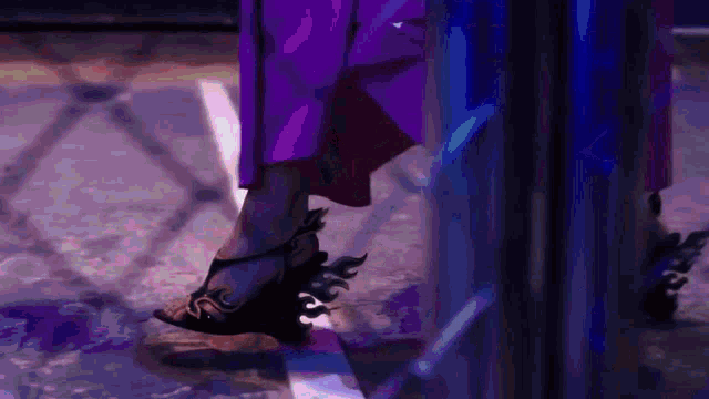 a woman in a purple dress is wearing a pair of black shoes with flames on them .