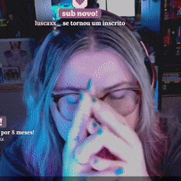 a woman wearing glasses covering her face with her hands with a sub novo sign in the background