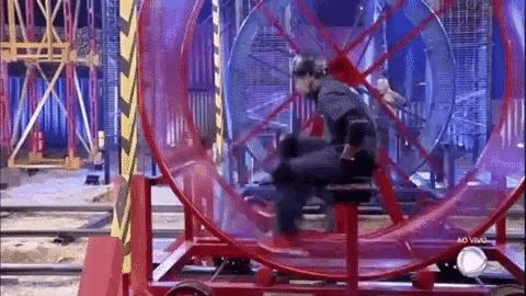 a woman is sitting on top of a ferris wheel in a dark room .