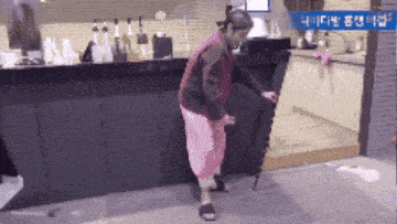 a woman in pink pants is standing in front of a counter with a blue sign above her that says ' a '