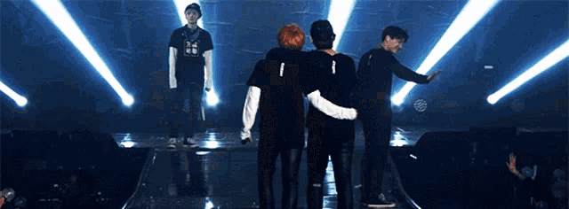 a group of men are standing on a stage and one of them has the number 1 on their shirt