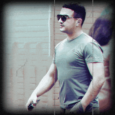 a man wearing sunglasses and a t-shirt with the letter g on the front