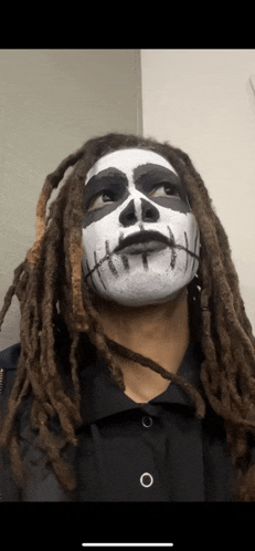 a man with dreadlocks and a skeleton face painted on his face