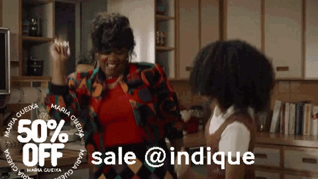 a woman and a child are dancing in a kitchen with the words 50 % off sale @ indicque