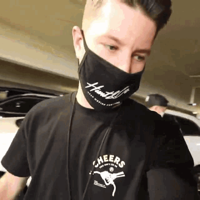 a man wearing a black shirt that says heers