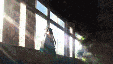 a girl with long hair is standing in front of a window