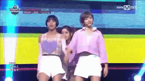a group of girls are dancing on a stage with a sign that says mnet on it