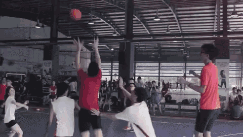 a group of people playing basketball in a gym