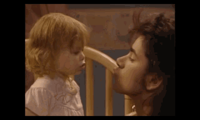 a man kissing a little girl on the cheek