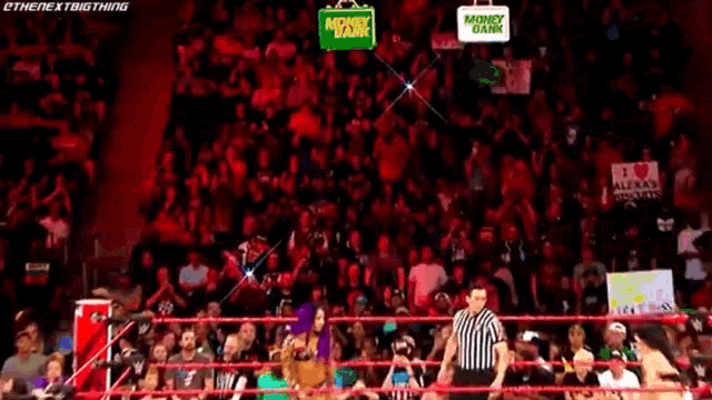 a referee is standing in a wrestling ring with a crowd of people watching .