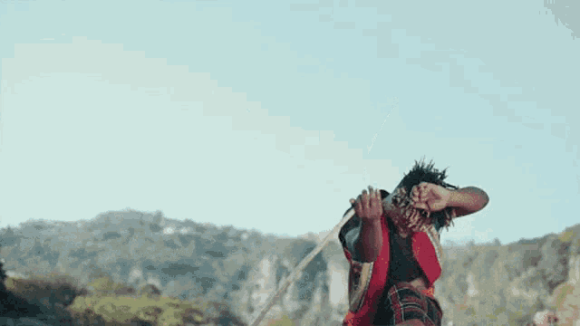 a man in a kilt is jumping in the air with a sword