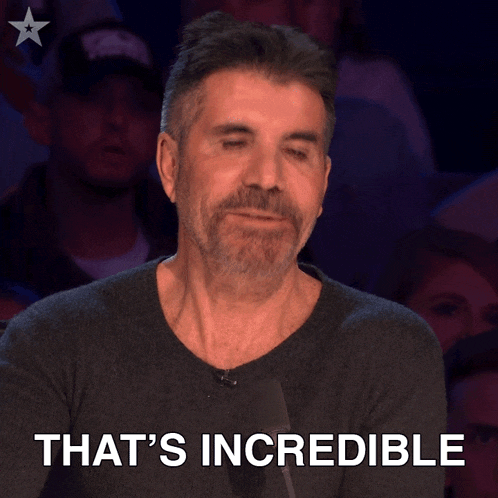 a man with a beard stands in front of a crowd and says that 's incredible