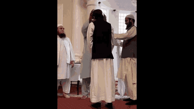 a man with a beard is standing next to a group of men