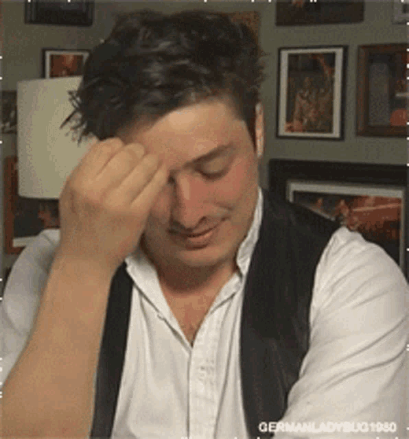 a man in a white shirt and black vest has germanladybug1960 written on the bottom