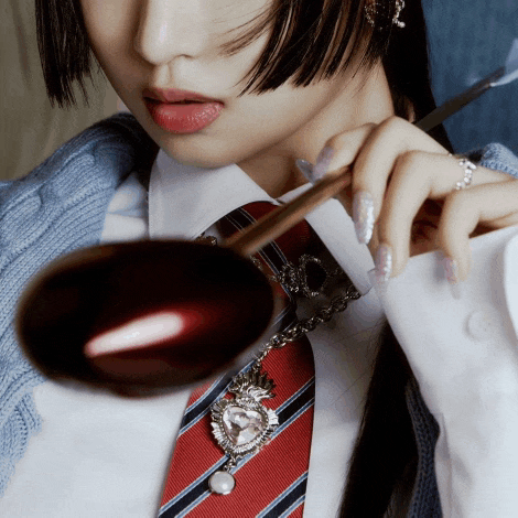 a woman in a white shirt and red tie is holding a ladle