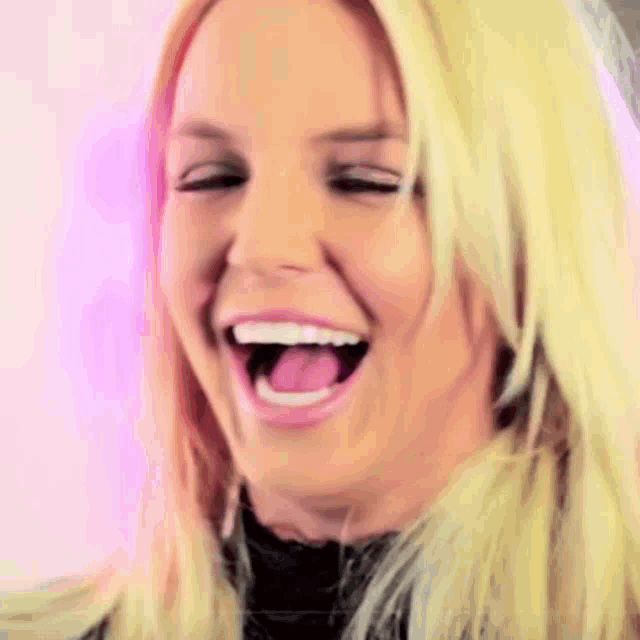 a close up of a woman laughing with her mouth open