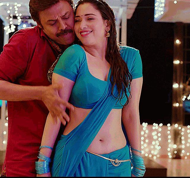 a man in a red shirt is touching a woman 's stomach