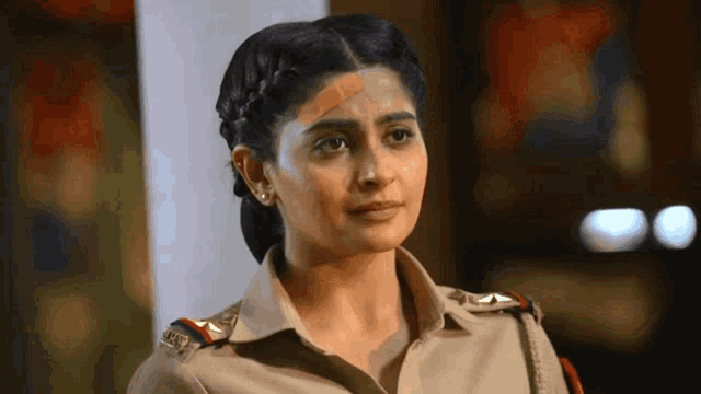 a woman in a police uniform has a bandage on her forehead .