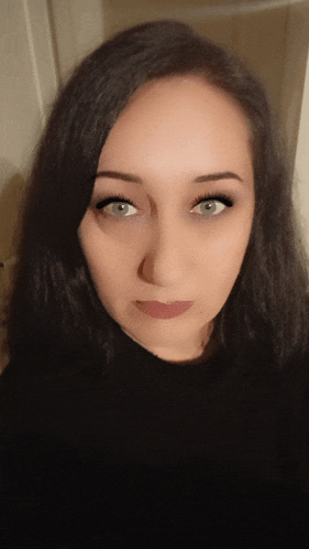 a close up of a woman 's face with long black hair