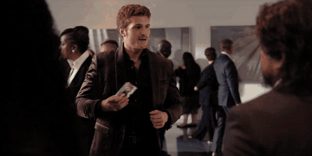 a man in a purple jacket is talking to a man in a black shirt