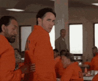 two men in orange jumpsuits with doc on the back
