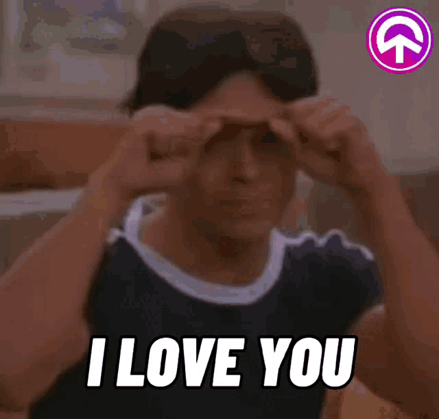 a man is holding his hands to his forehead and says `` i love you '' .